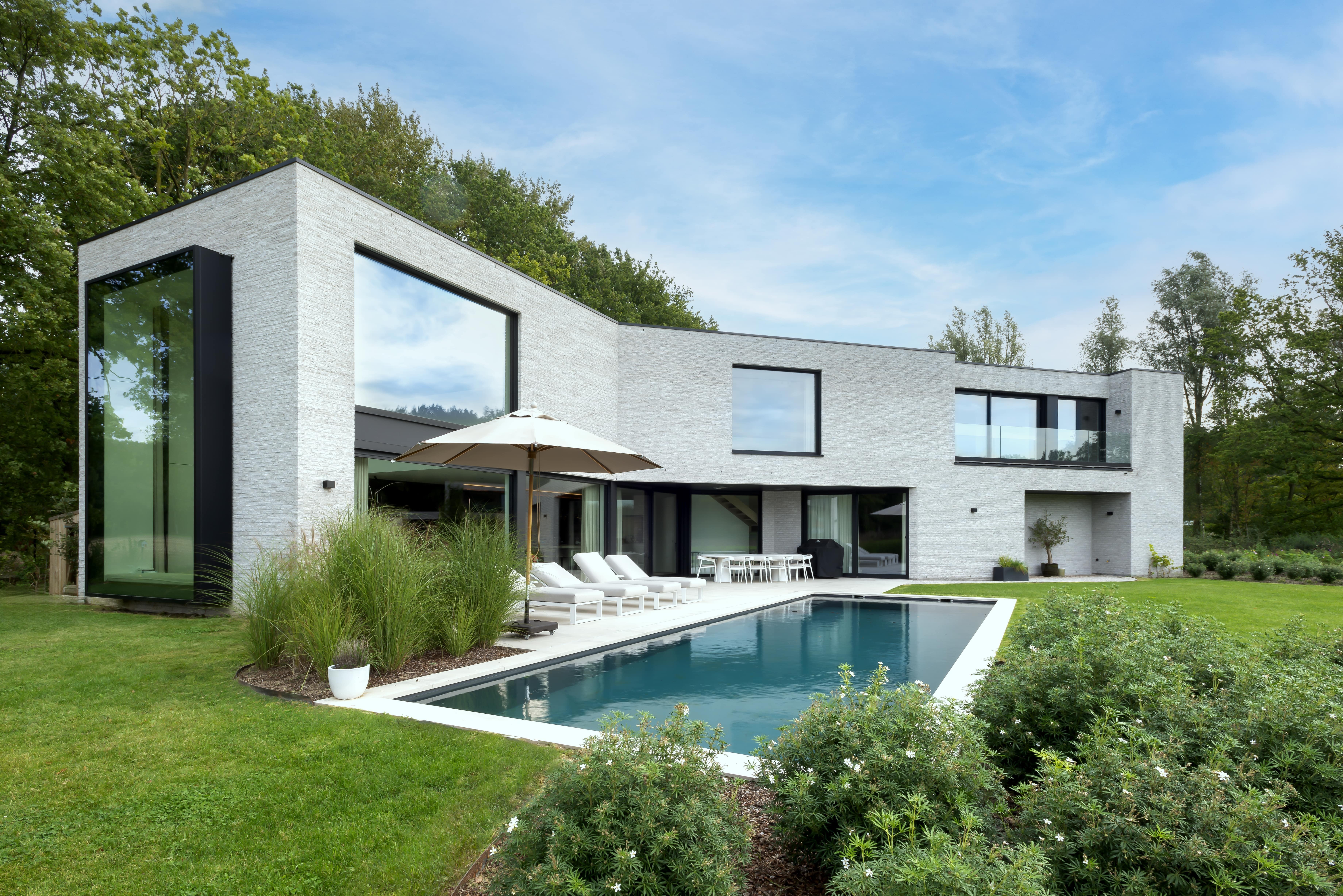 Moderne nieuwbouwwoning met tuin en rechthoekig zwembad, realisatie van Plan Architectenbureau Brugge